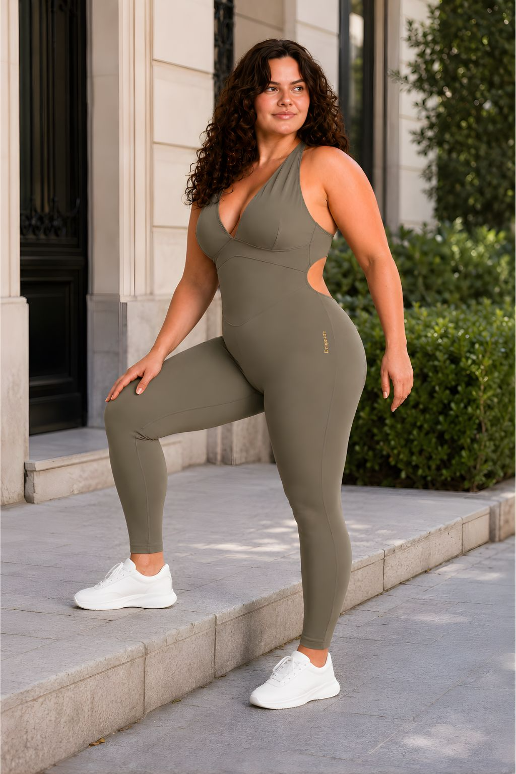Woman wearing olive DropTrou women's jumpsuit - large movement view #Size_L