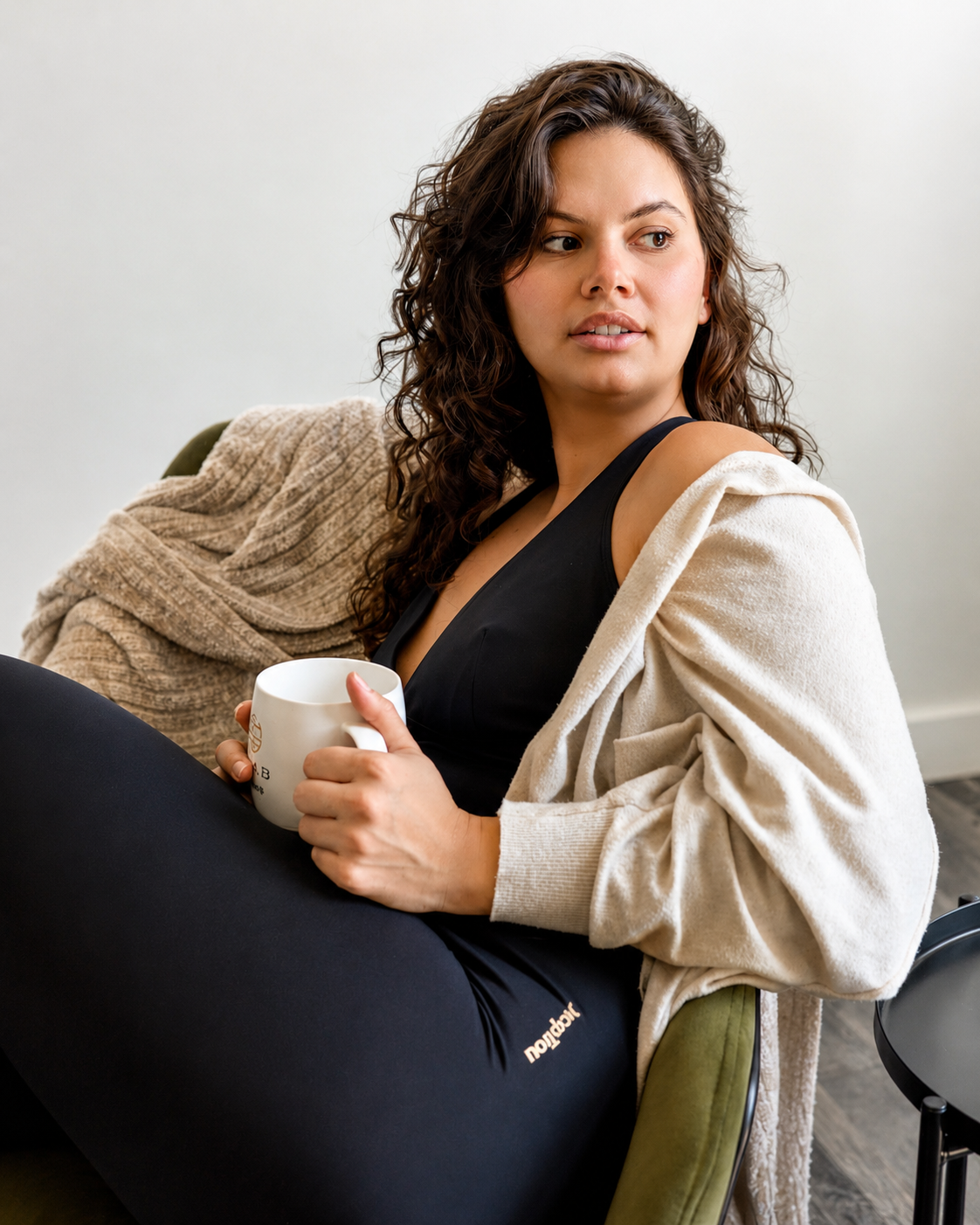 Woman wearing black DropTrou women's jumpsuit - large cozy lounge lifestyle view #Size_L